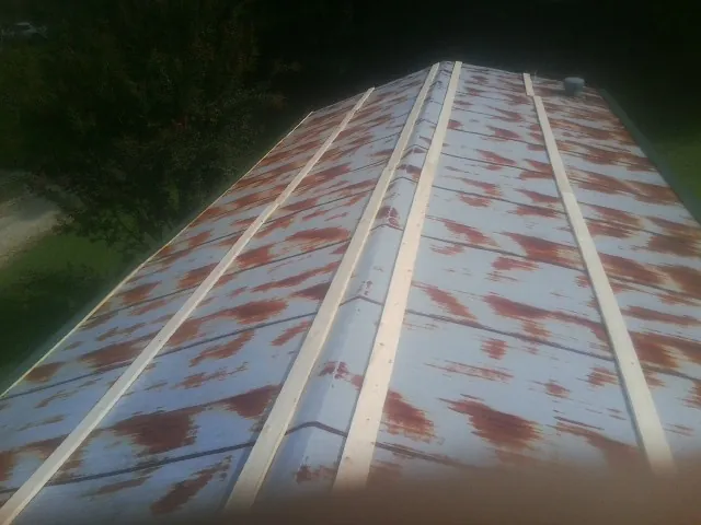 Rusted metal roof panels with new wood purlins before replacement — Storm Damage Roof Repair in Freeland by Roofing Brothers